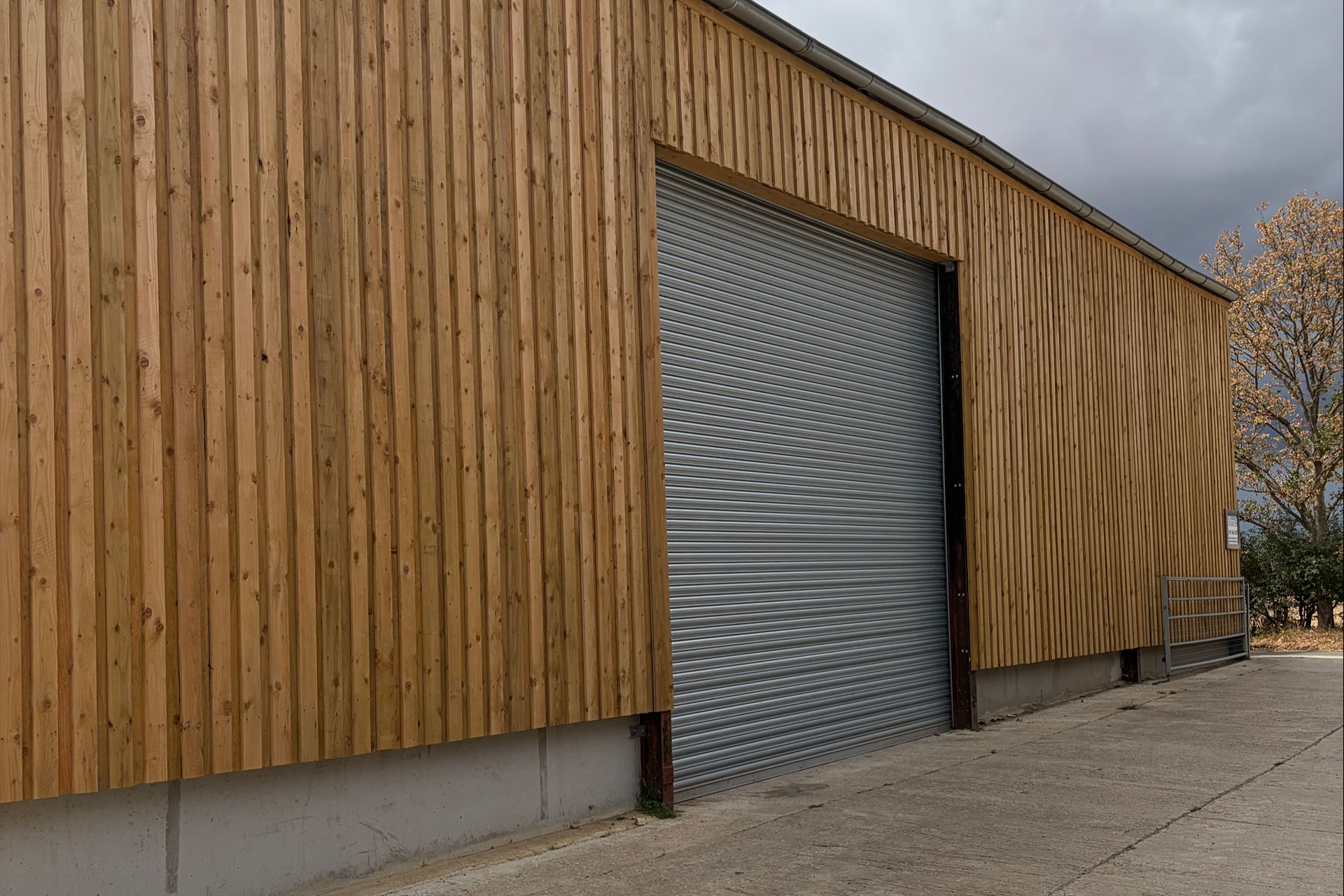 Newly built timber-clad storage building with roller shutter door at Mill Farm