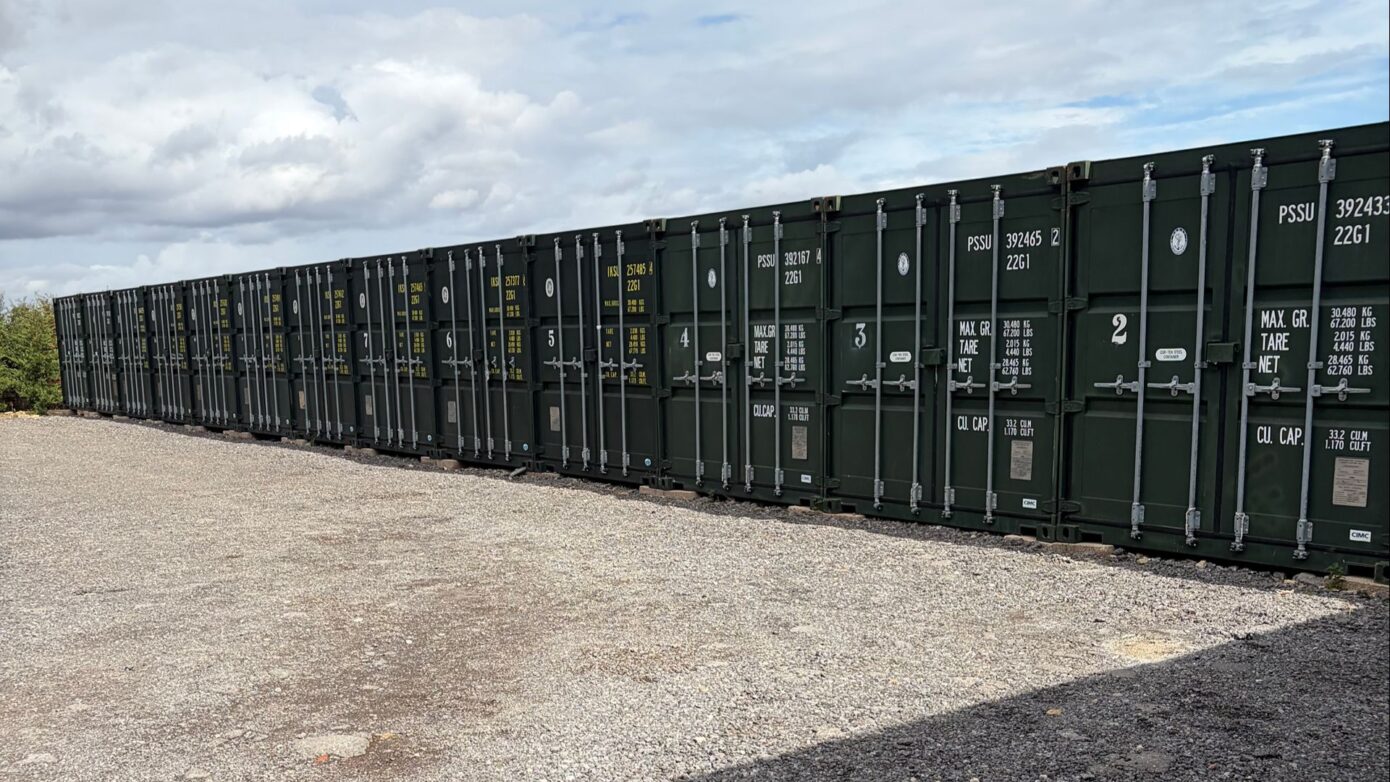 Row of numbered green storage containers with secure locking bars